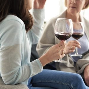 Close up of two women drinking wine at home