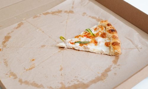 Eaten pizza, one piece on food delivery box.